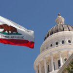 California Capitol building in Sacramento with state flag flying.